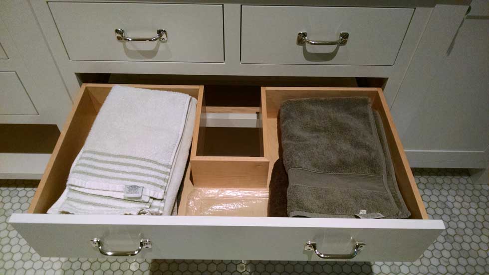 Open drawer in white bathroom cabinets