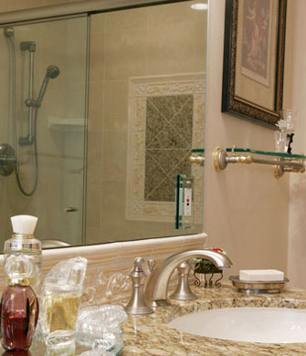 Close up of sink with shower reflected in mirror