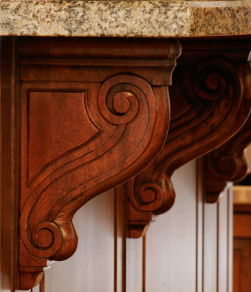 Close up of cherry wood corbels under counter tops in remodeled kitchen