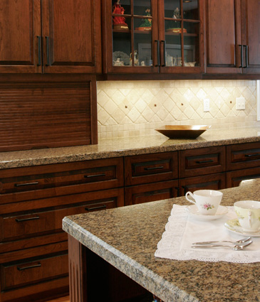 Chery wood cabinets, granite counter top, and tumbled tile backsplash in remodeled kitchen